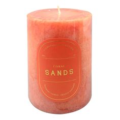 an orange candle with the words sands on it's front and side, against a white background