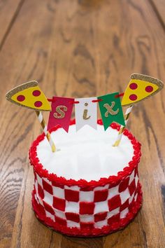 a red and white cake sitting on top of a wooden table