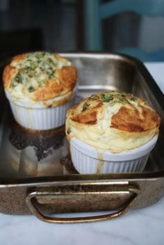 two muffins sitting on top of a metal pan