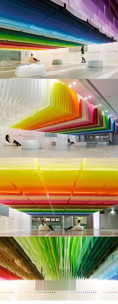 the ceiling is made up of multicolored lines and people are sitting on benches