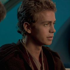 the young man is staring at something while wearing earring necklaces on his neck