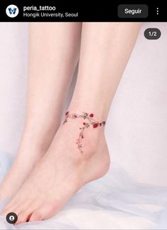 a woman's foot with flowers on it and the words peria tattoo written in red ink