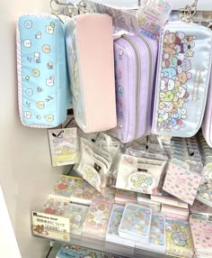 there are many bags and wallets on display in the store, including one with hello kitty