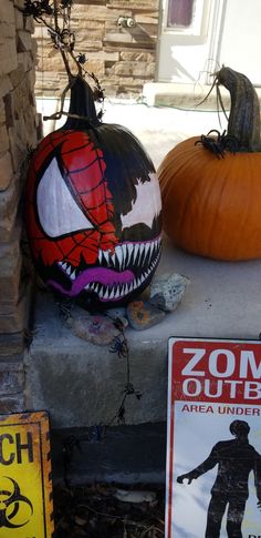 two pumpkins are sitting on the porch with zombie signs next to them and a sign that says, zoom out