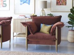 two brown chairs sitting next to each other in a living room