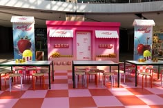 a pink and white checkered floor with tables and chairs in front of the kiosk