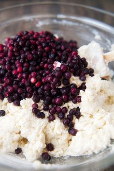 cranberries and mashed potatoes in a glass bowl on top of a wooden table