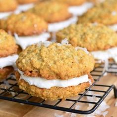 several cookies are cooling on a rack with icing and white frosting around them