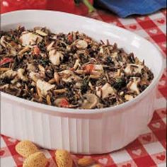 a white bowl filled with food on top of a red and white checkered table cloth