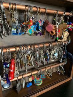 a bunch of key chains are hanging on a rack in a room with other items