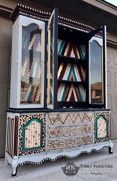 an ornately decorated cabinet is shown in front of a garage