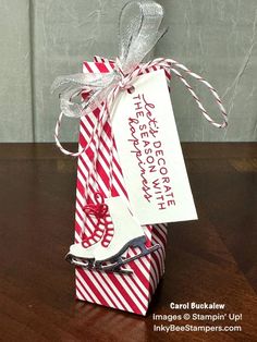 a red and white striped gift bag with a silver ribbon tied around the tag that says happy new year