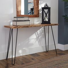 a wooden table with hairpin legs and a mirror on the wall in front of it