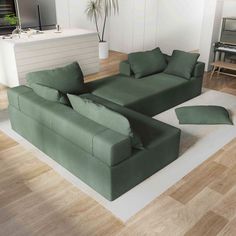 a large green couch sitting on top of a wooden floor