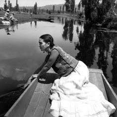 a woman sitting in a boat on the water