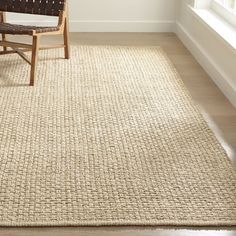 a chair sitting on top of a wooden floor next to a rug