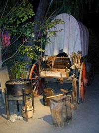 an old covered wagon sitting next to a tree