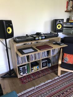 there is a desk with speakers and music equipment in the living room on top of it