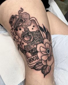 a woman's thigh with a train and flowers on it