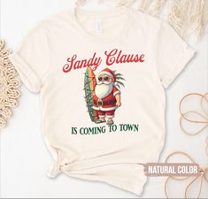 Unisex Funny 'Sandy Clause is Coming to Town' Beach Santa Shirt, Tropical Christmas Palm Tree Shirt, Florida Xmas T-shirt, Hawaiian Beach Christmas Tee Gift Description: Celebrate the holidays with a fun twist on a classic! This "Sandy Clause is Coming to Town" beach Santa shirt brings a tropical vibe to your Christmas wardrobe. Perfect for sunny celebrations, it's an ideal gift for those who love the beach or are spending Christmas in warm, tropical destinations like Florida or Hawaii. 🌴🎅 Unique beach-themed Christmas shirt featuring a funny Santa design Lightweight, breathable fabric, perfect for hot weather Christmases Vibrant tropical print with palm trees and a festive holiday feel Great gift for beach lovers, Florida residents, or Hawaiian Christmas vibes Available in multiple size Tropical Christmas Outfit Women, Tropical Xmas, Palm Tree Shirt, Christmas Palm Tree, Christmas Wardrobe, Funny Beach, Florida Christmas, Hawaiian Christmas, Beach Humor