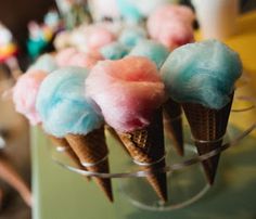 there are ice cream cones with different colored toppings on top of each one in a glass bowl