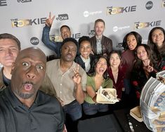 a group of people posing for the camera with their fingers up in front of them