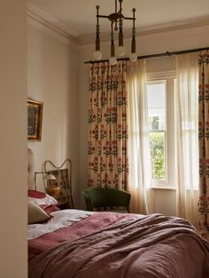 a bed sitting under a window in a bedroom