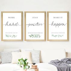 three framed posters on the wall above a white couch in a living room with a potted plant