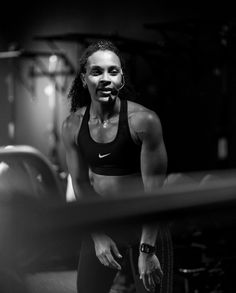 a black and white photo of a woman in a gym