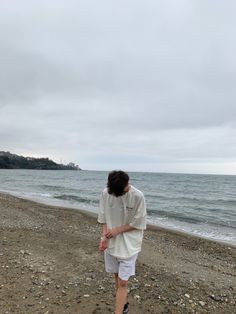 a person walking on the beach near the water