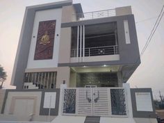 the front of a modern house with an iron gate and decorative artwork on the wall