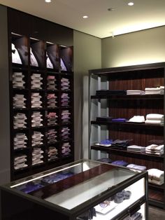 a large display case filled with men's shirts in a room full of shelves