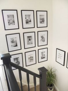 a staircase with black and white pictures on the wall