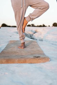 a person standing on top of a snow covered ground with their feet in the air