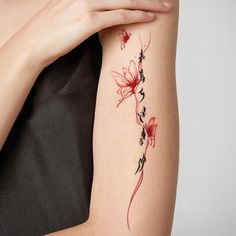 a woman's arm with a flower tattoo on the left side of her arm