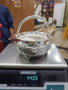 a silver basket sitting on top of a scale