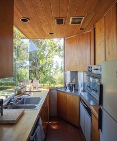 a kitchen with wooden cabinets and stainless steel appliances, along with an open floor plan