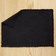 a black piece of cloth laying on top of a wooden floor