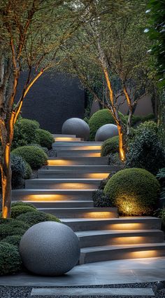 an outdoor garden with steps lit up by lights and trees in the background at night