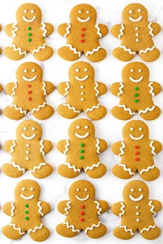 many ginger cookies are arranged in rows on a white surface