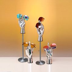 three metal sculptures with sunglasses on top of each other and one is holding up his hand