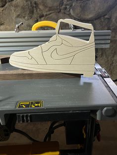 a pair of shoes sitting on top of a table next to a piece of wood