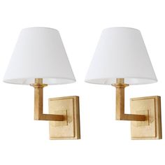 two wall lamps with white shades on them