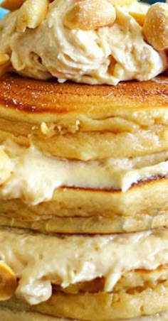 stack of pancakes topped with whipped cream and walnuts