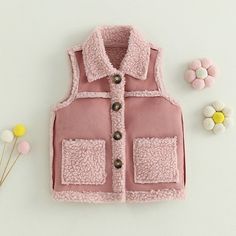 Keep your little snowball warm and comfy this winter season and in style in this stunning pink vest with plush details. Cute Pink Vest For Spring, Cute Pink Cotton Vest, Pink Cotton Outerwear With Fleece Lining, Playful Pink Winter Outerwear, Pink Cotton Vest For Fall, Cute Pink Outerwear With Pockets, Pink Sleeveless Cotton Outerwear, Pink Sleeveless Outerwear For Fall, Sleeveless Pink Outerwear For Fall