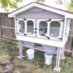 a large gray and white bird house with two birds in it's cages