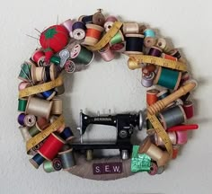 an old sewing machine has been decorated with ribbons and spools of thread to make a wreath