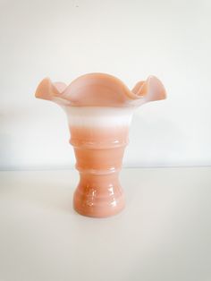 an orange vase sitting on top of a white table