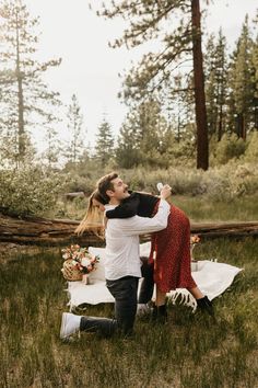 a man and woman sitting in the grass near each other with food on their hands