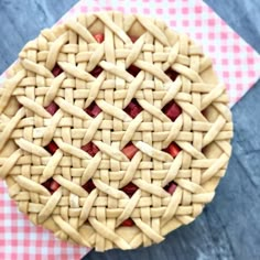 a pie sitting on top of a pink and white checkered table cloth